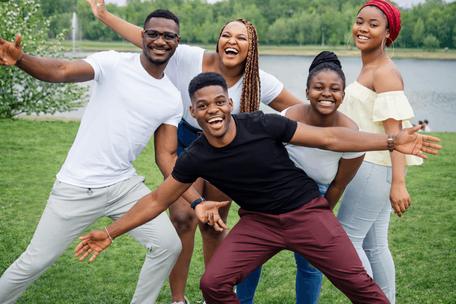 Silhouette of a person with arms raised against a vibrant sunset and cloudy sky.