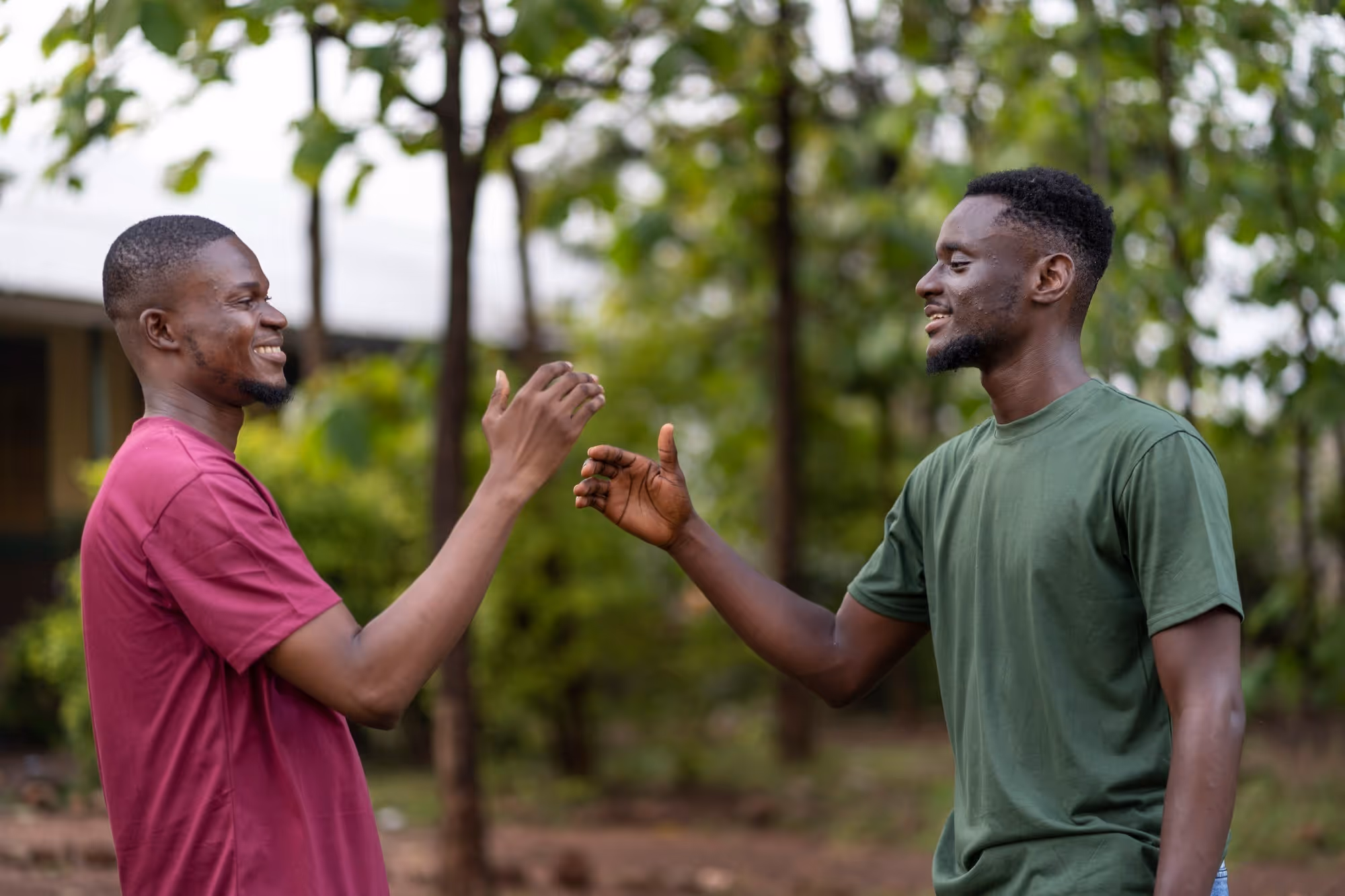two friends shake hands smiling at each other